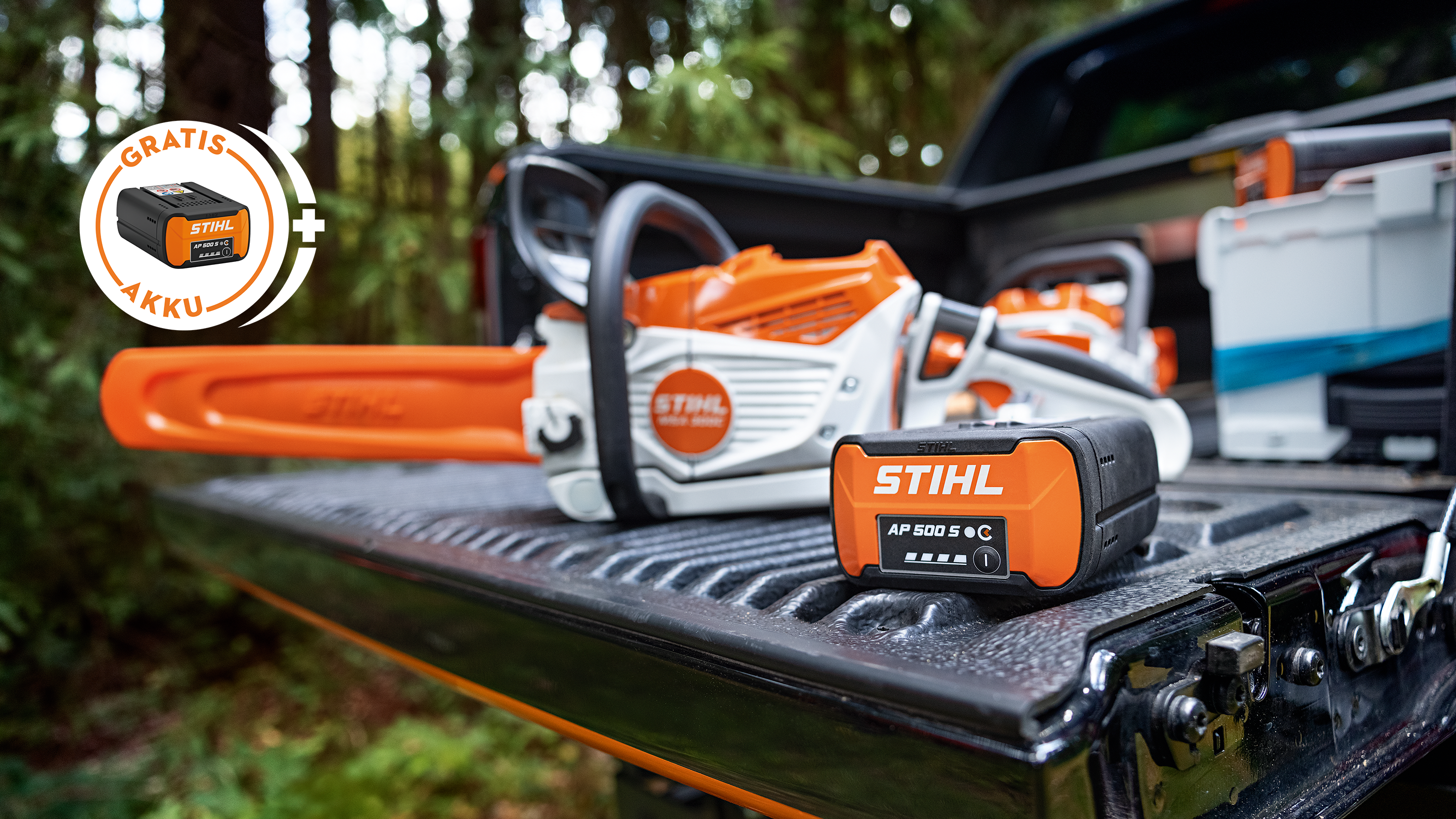 STIHL Akku AP 500 S auf der Ladefläche eines Pickups zusammen mit der neuen STIHL Akku-Motorsäge MSA 300, zusätzlich ein Hinweis-Störer mit STIHL Akku und der Aufschrift „Gratis Akku“.